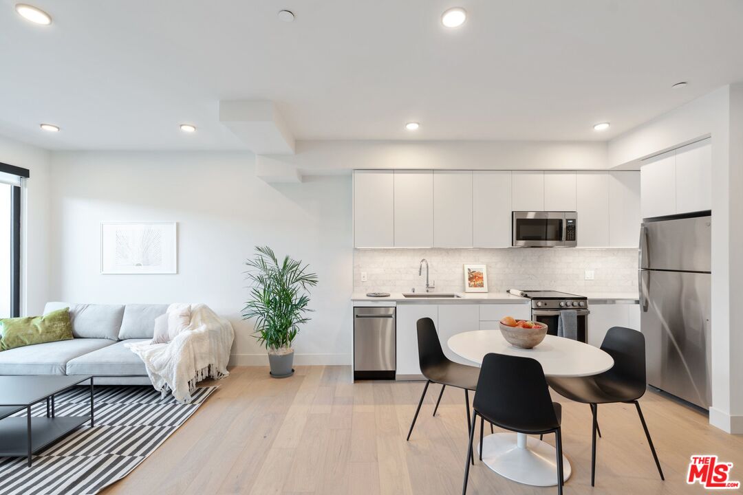 a kitchen with kitchen island a stove a table and chairs