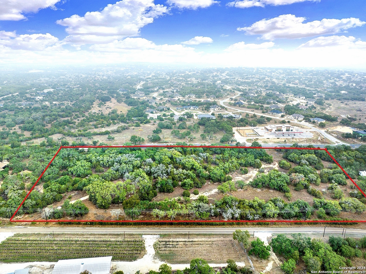 an aerial view of residential houses with outdoor space and trees