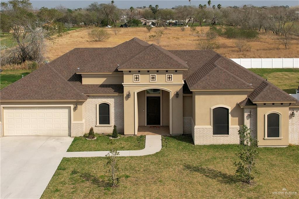 a aerial view of a house with a yard and lake view