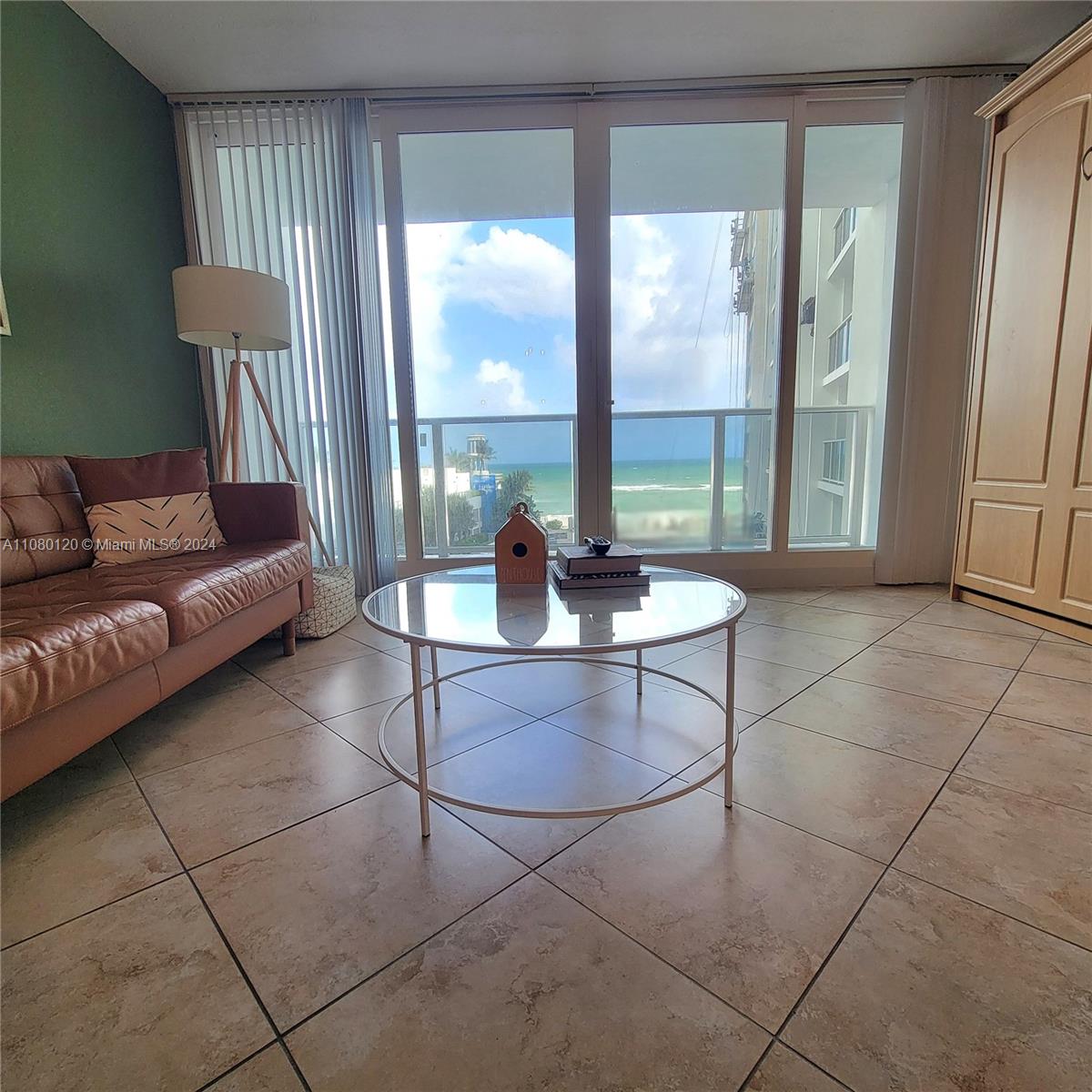 a living room with patio furniture and a floor to ceiling window