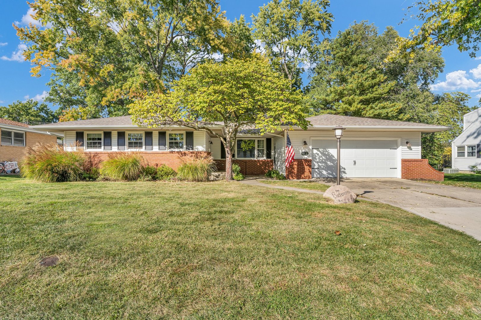 a front view of house with yard and trees around