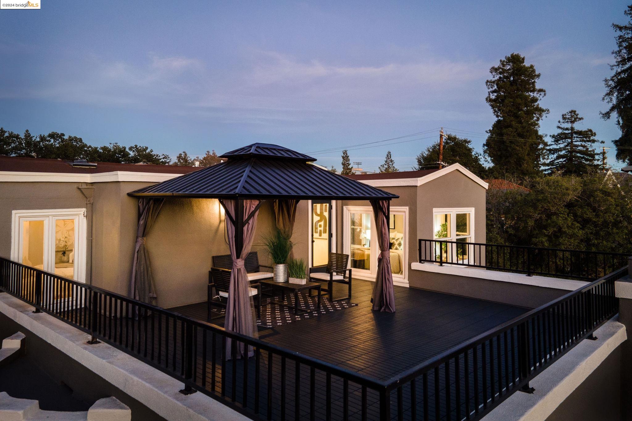 a view of a patio with table and chairs with wooden floor and fence