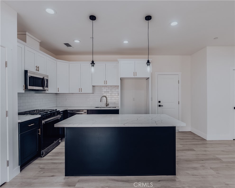 a kitchen with kitchen island sink stove and refrigerator