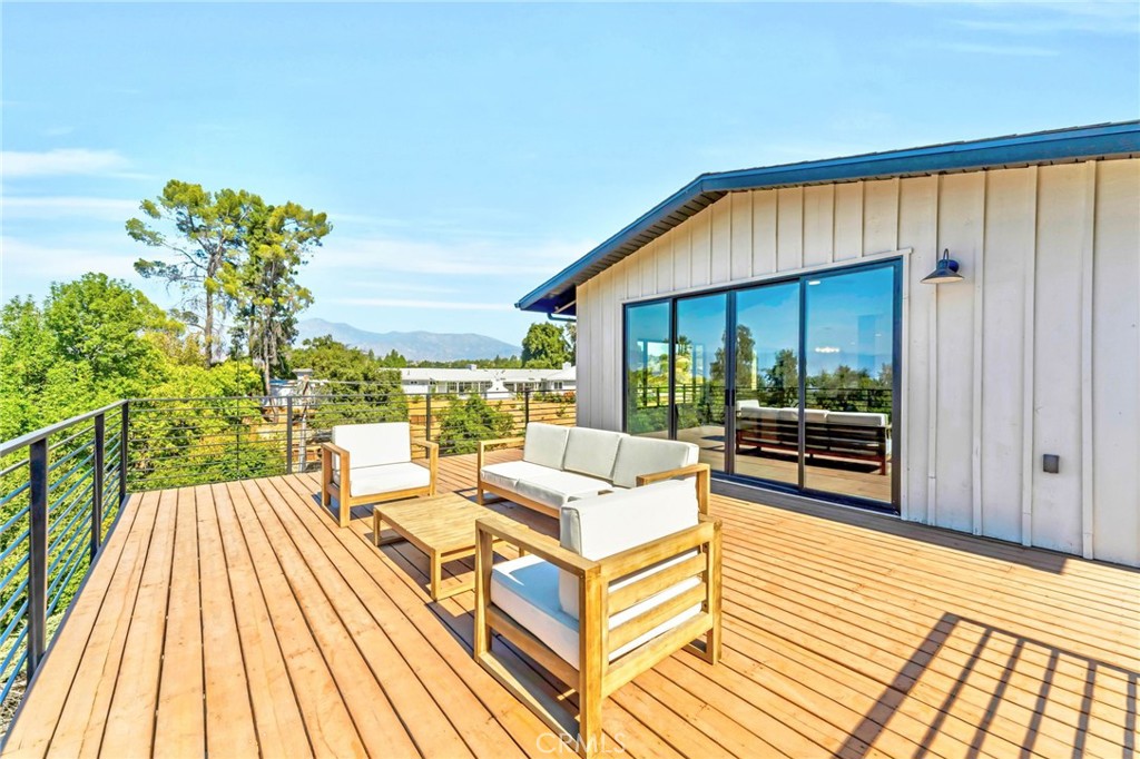 a view of a balcony with chairs and wooden floor