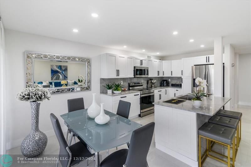 a kitchen with white cabinets and refrigerator