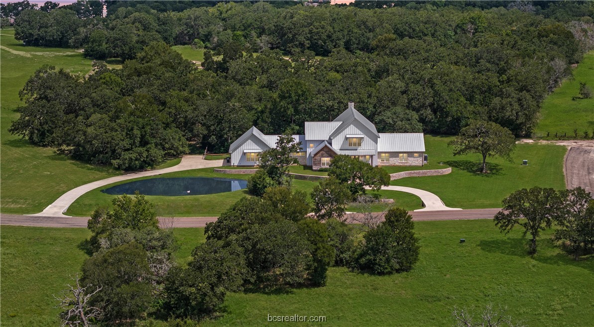 an aerial view of a house having swimming pool patio and lake view