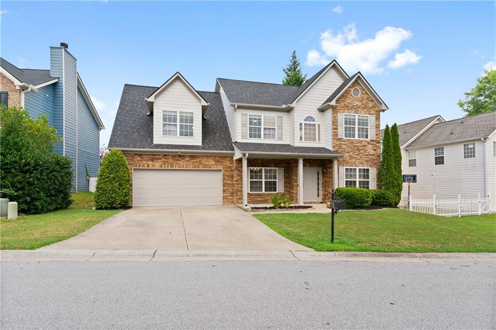 a front view of a house with a yard and garage