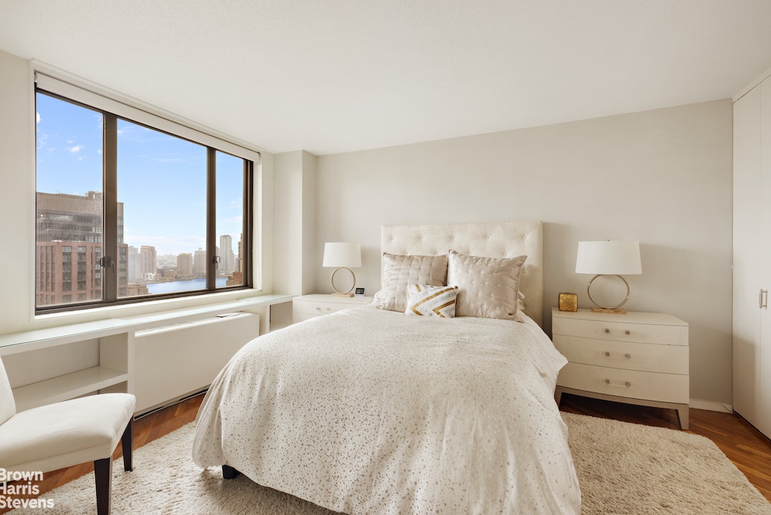 a spacious bedroom with a bed and large windows