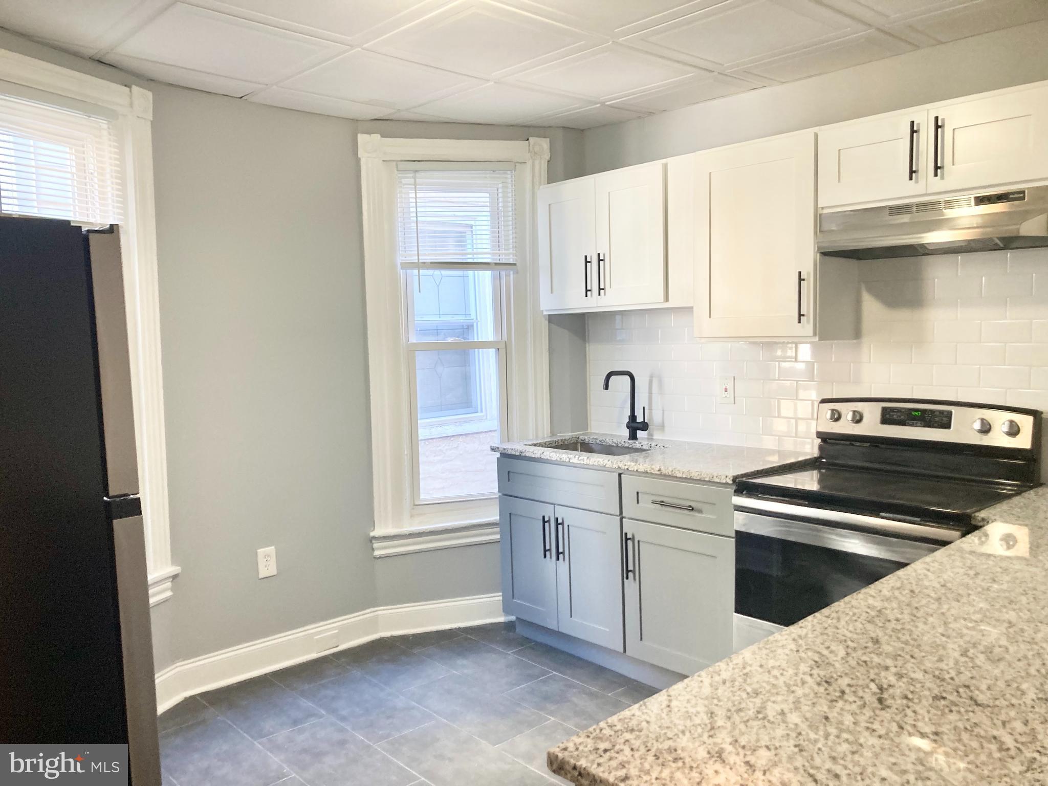 a kitchen with stainless steel appliances kitchen island granite countertop a sink and cabinets