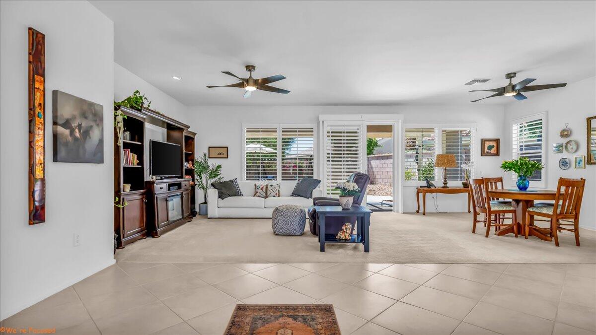 a living room with furniture a flat screen tv and a large window