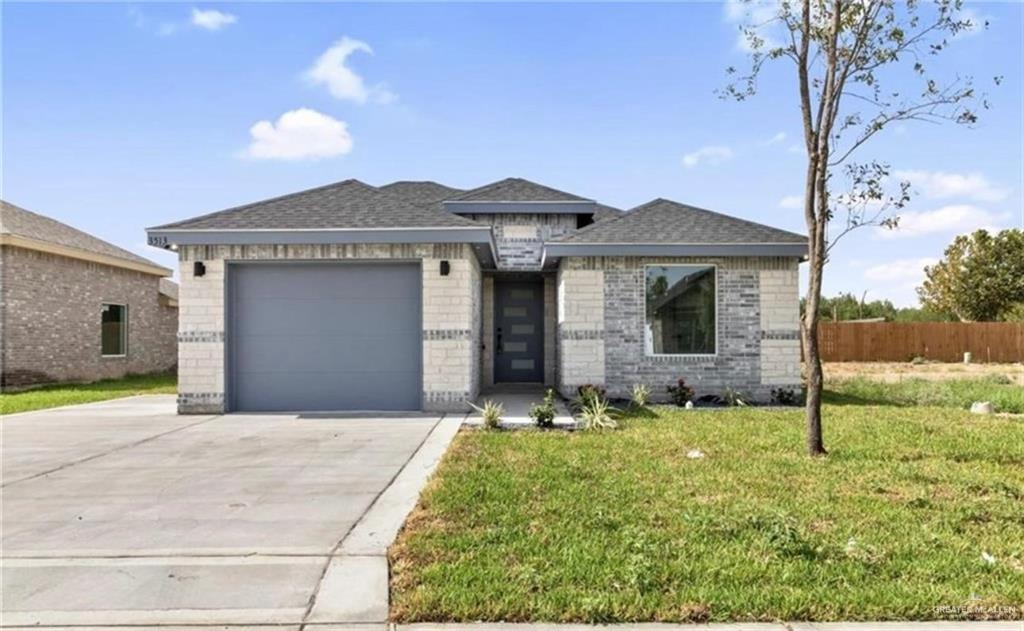 View of front of home featuring a garage and a front yard