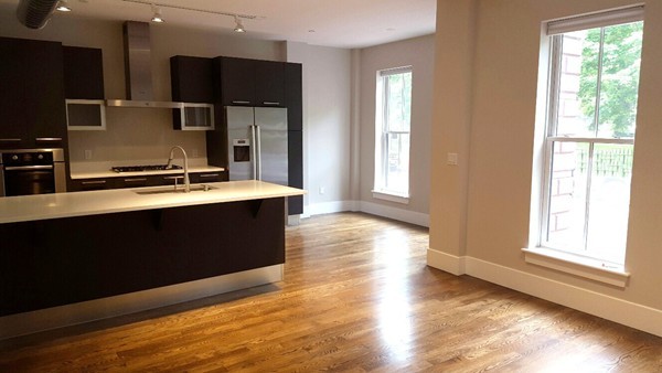 a kitchen with stainless steel appliances wooden floor and large window