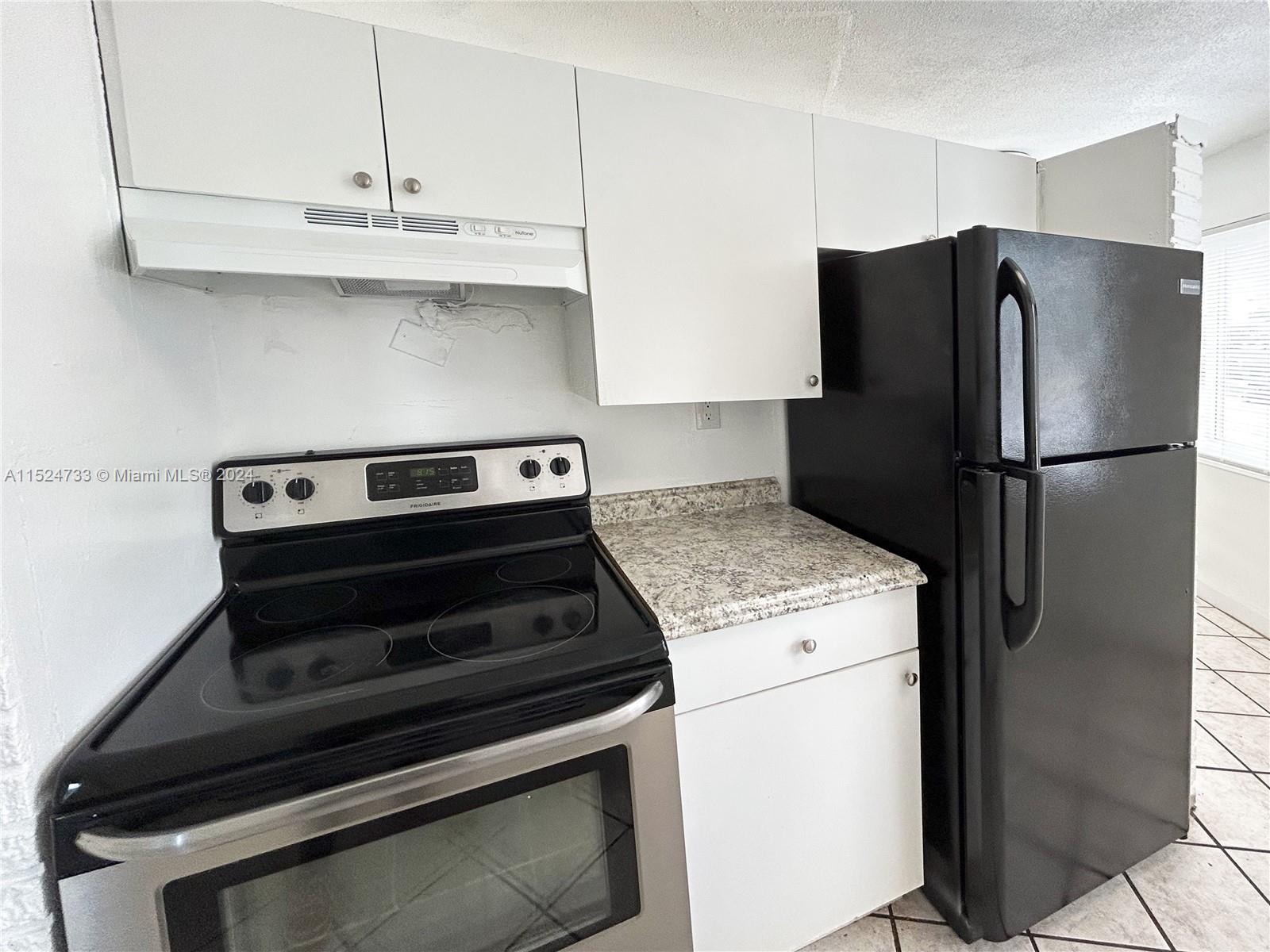 a kitchen with a stove refrigerator and cabinets