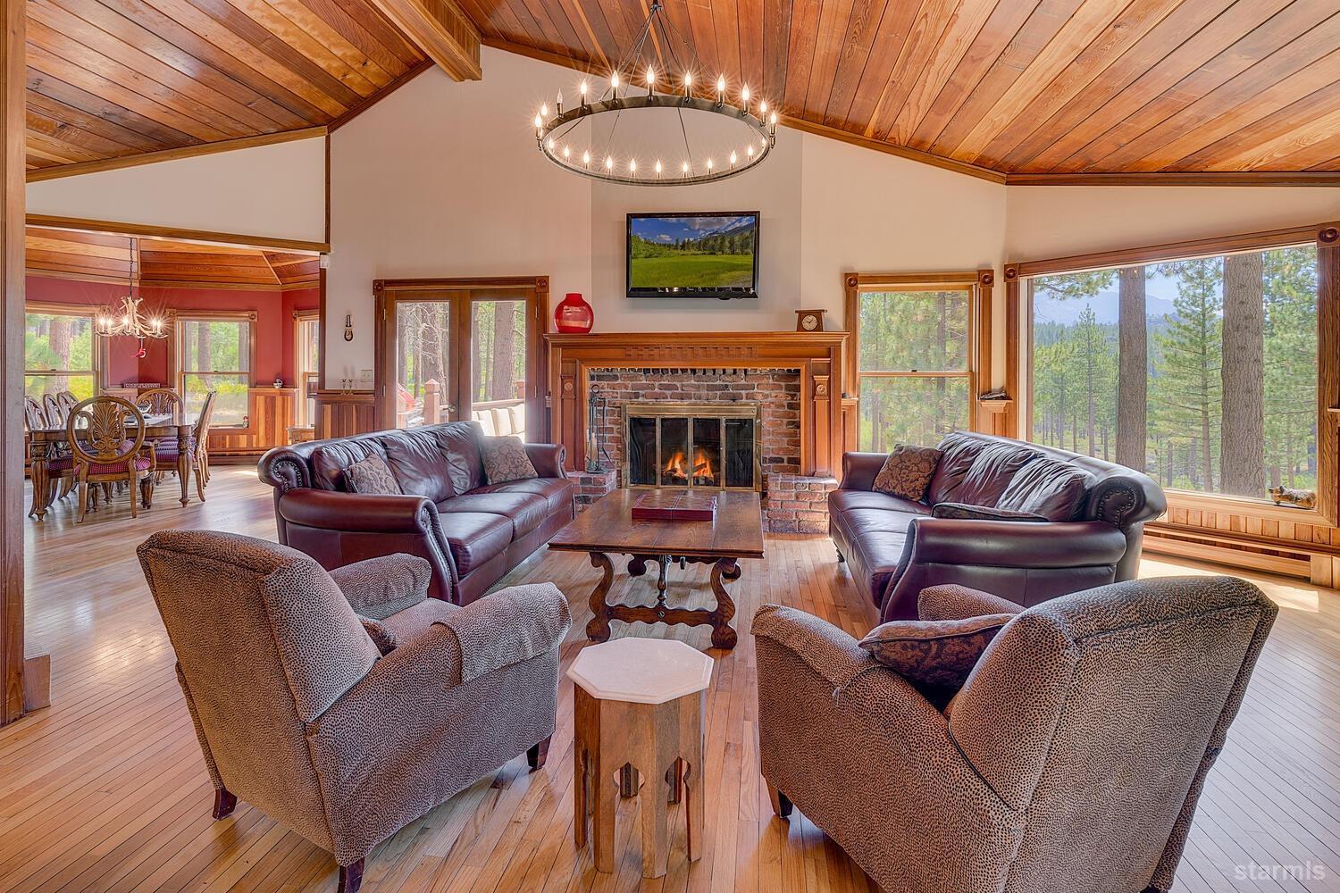 a living room with fireplace furniture and a large window