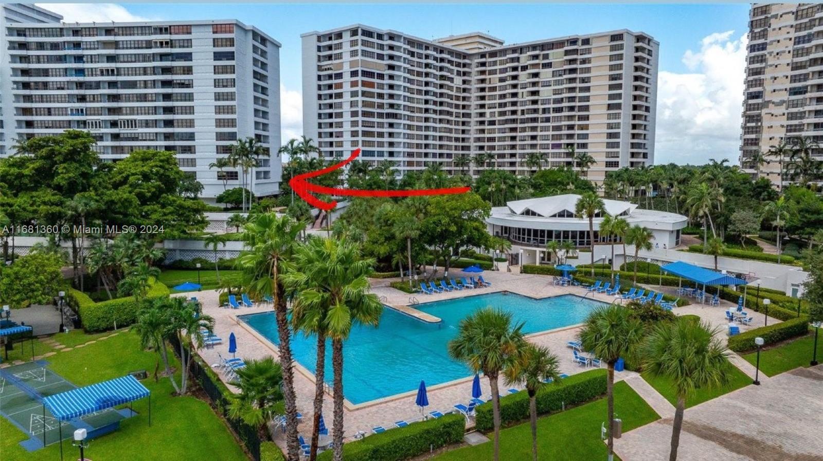 a view of lot of multi story residential apartment building with yard and outdoor seating