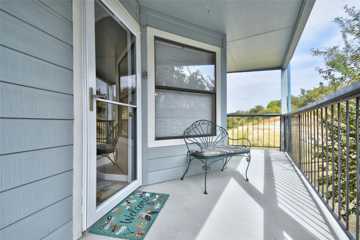 a view of a balcony with chairs and wooden floor