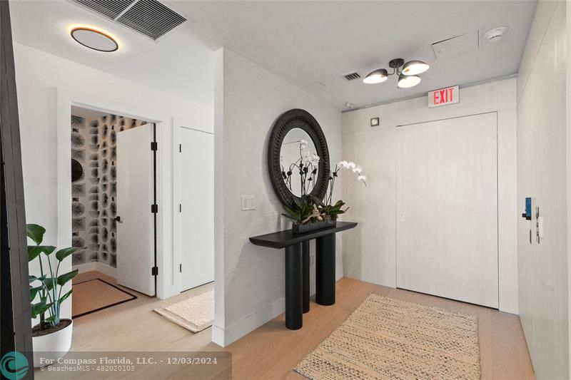 a view of a hallway with entryway wooden floor and front door