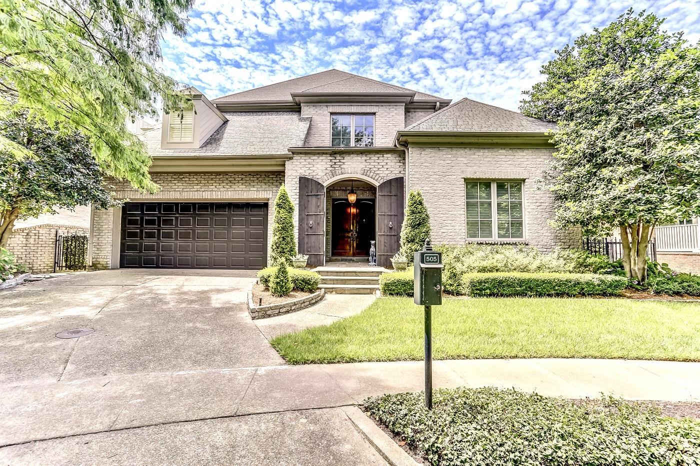 View of front of house with a garage and a front yard