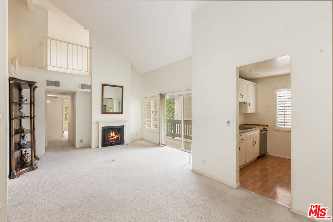 an empty room with fireplace and windows