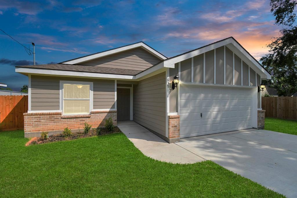 A newly constructed, single-story home with a modern facade, featuring a well-maintained lawn, a welcoming front porch, and a stylish entrance.