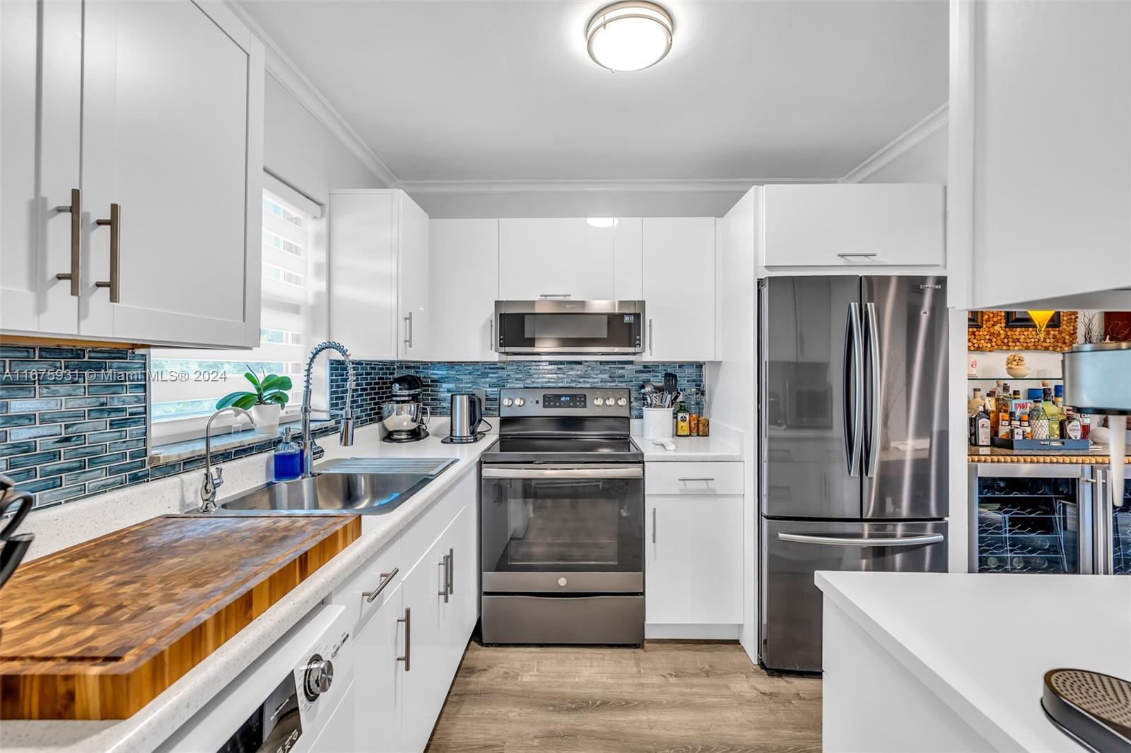 a kitchen with stainless steel appliances a refrigerator sink and microwave