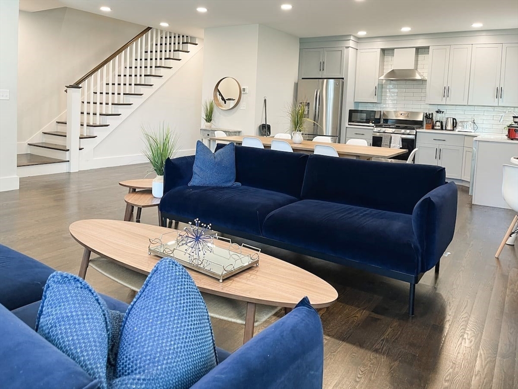 a living room with stainless steel appliances kitchen island granite countertop furniture a rug kitchen view and a kitchen island