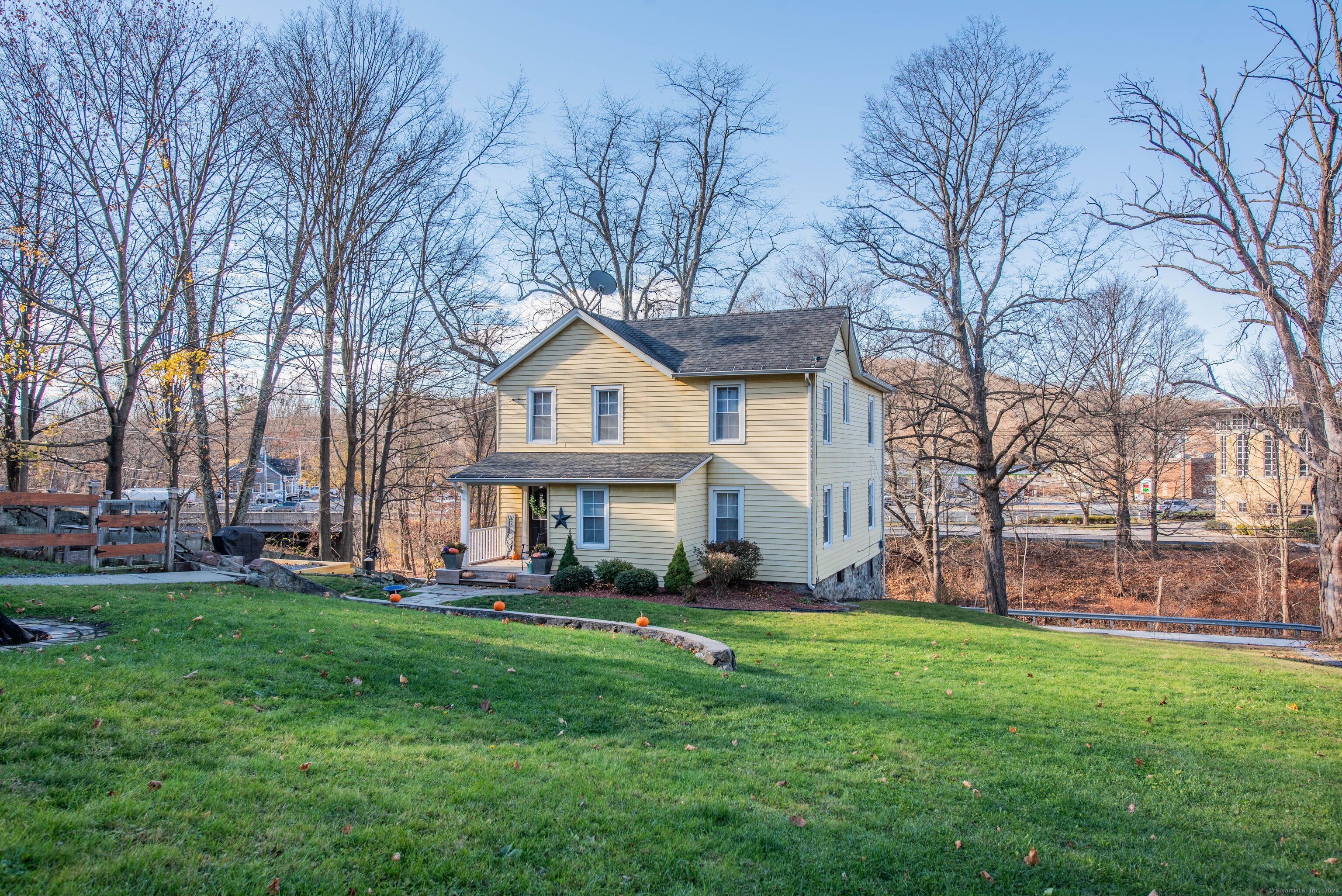 a front view of a house with a yard and trees