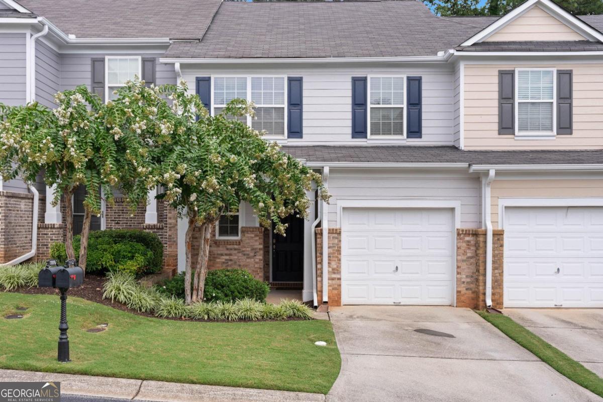 front view of house with a yard and potted plants