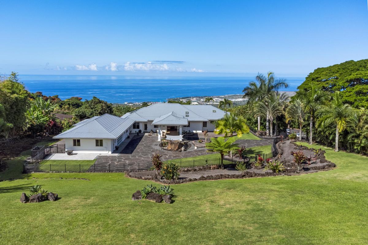 an aerial view of a house with garden space and street view