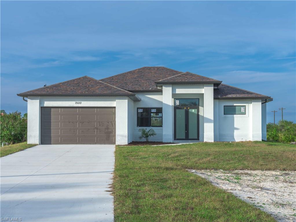 a front view of a house with yard and garage