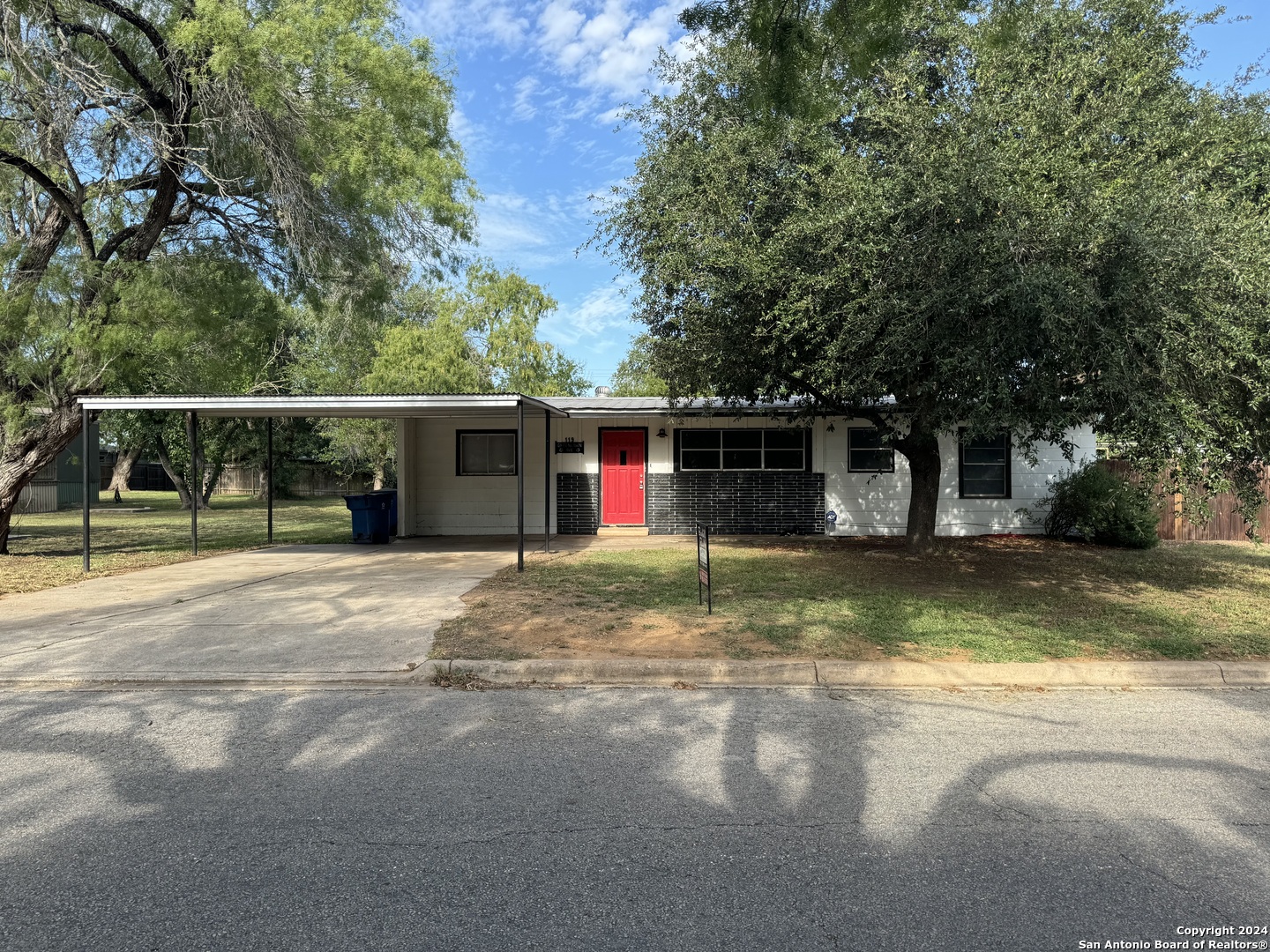 a view of a house with a yard and large tree