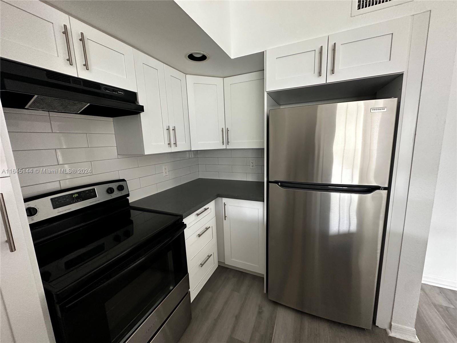 a kitchen with a refrigerator stove and cabinets