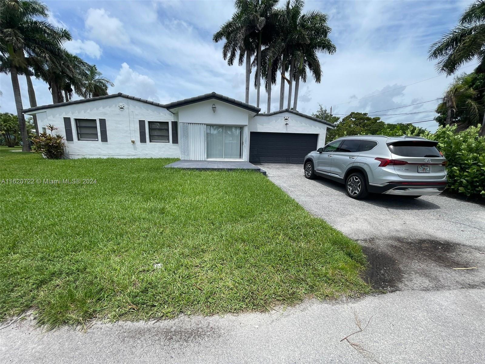 a front view of a house with a garden and parking