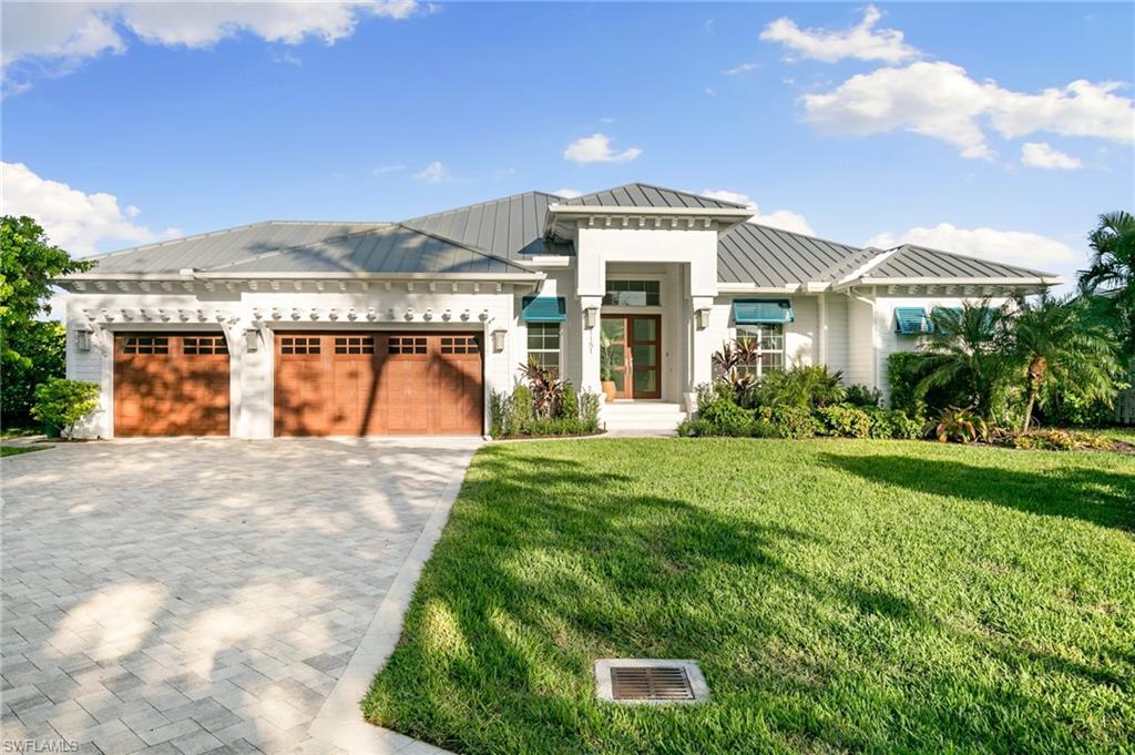 View of front of house with a garage and a front lawn