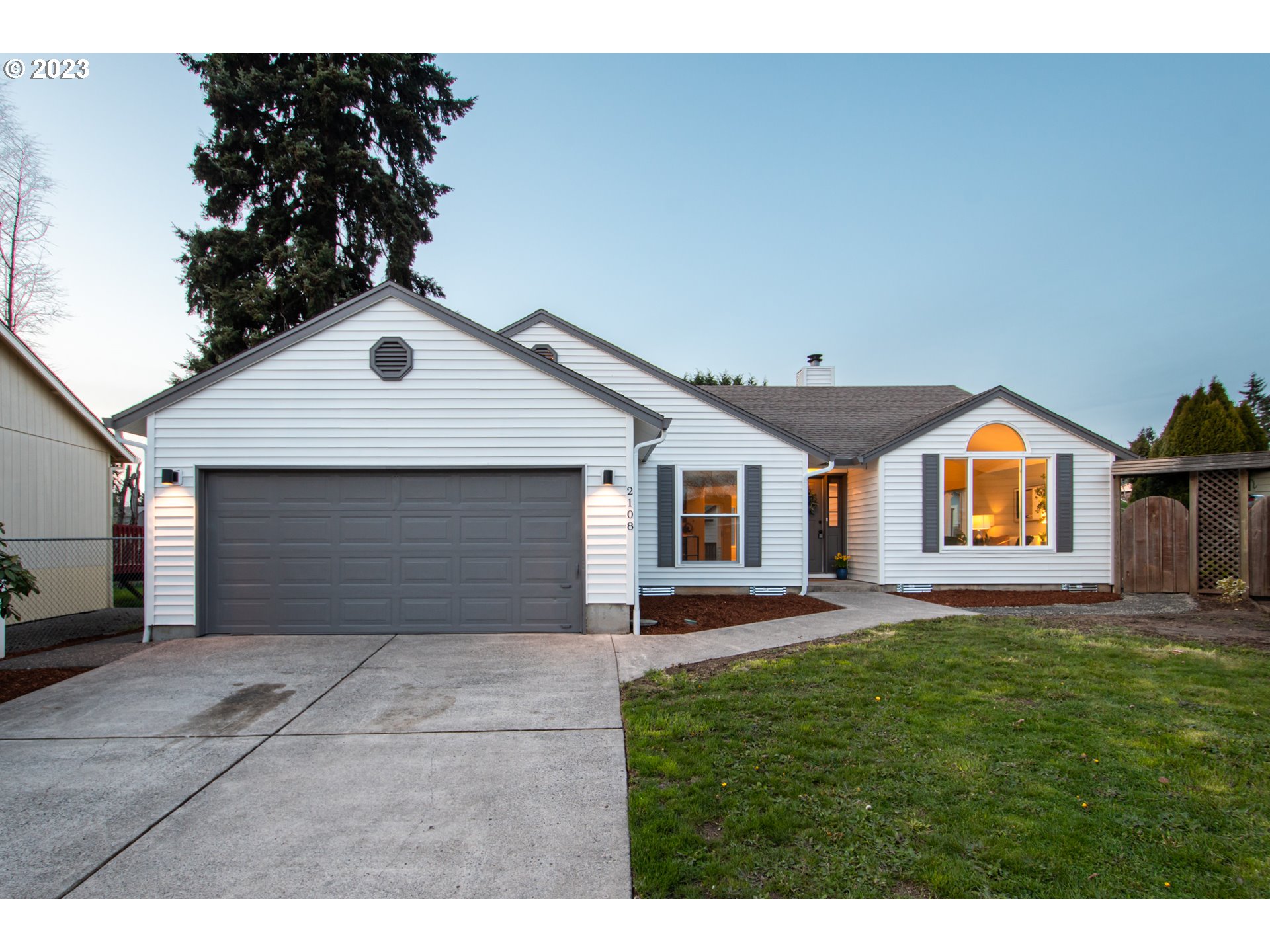 a front view of house with yard and trees in the background