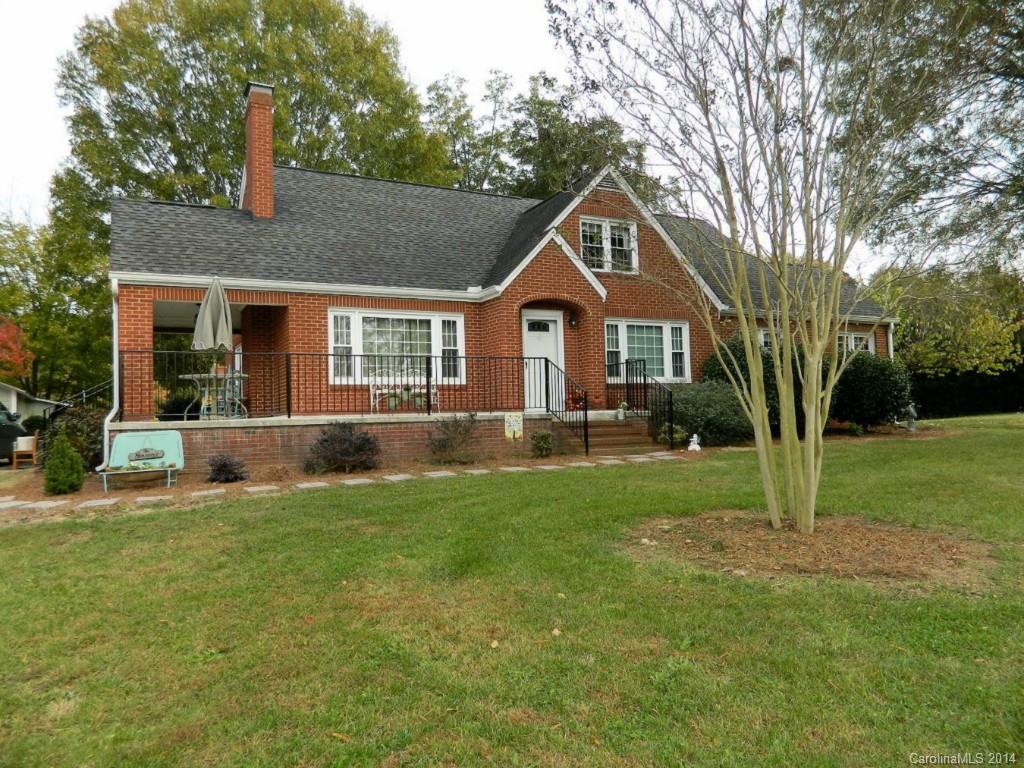 a front view of a house with a yard and trees