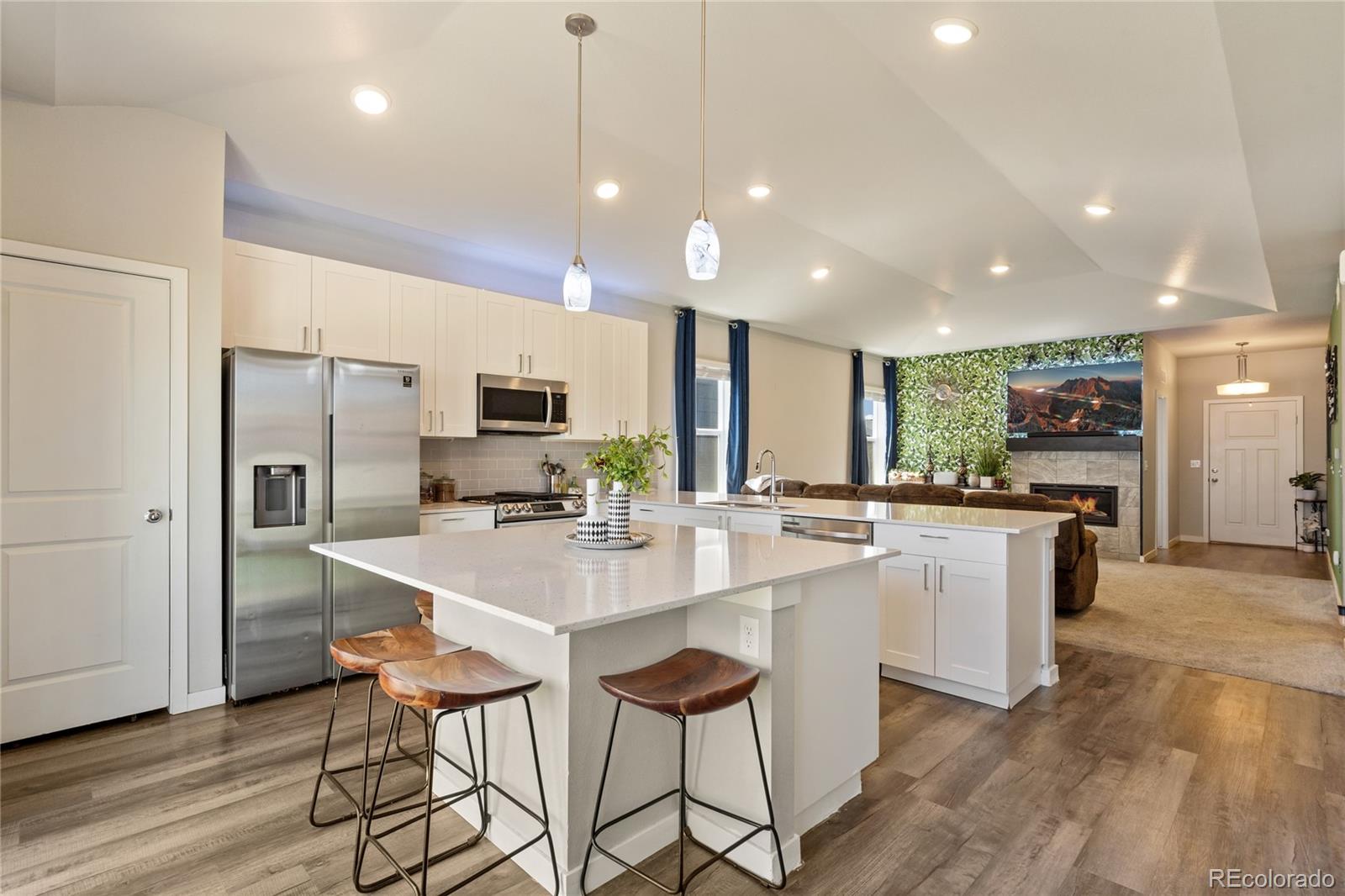 a kitchen with stainless steel appliances kitchen island granite countertop a sink and a refrigerator