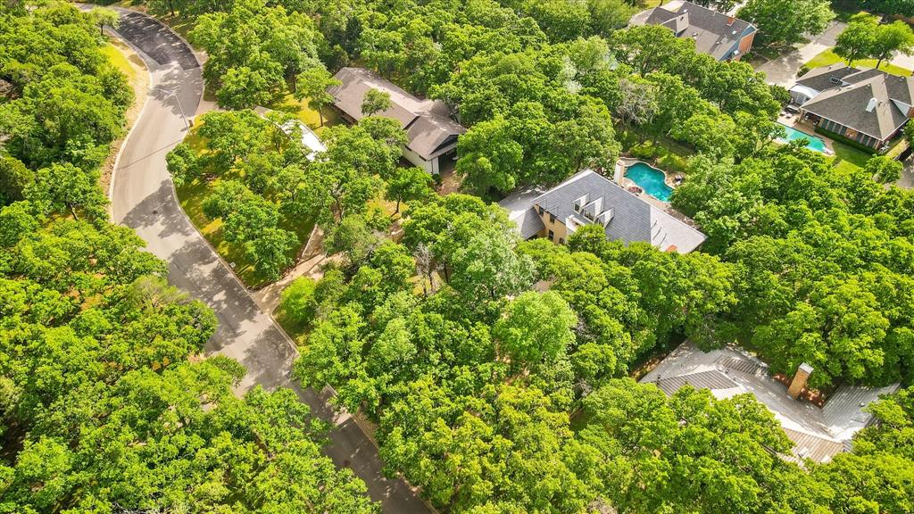 an aerial view of residential house with outdoor space and trees all around