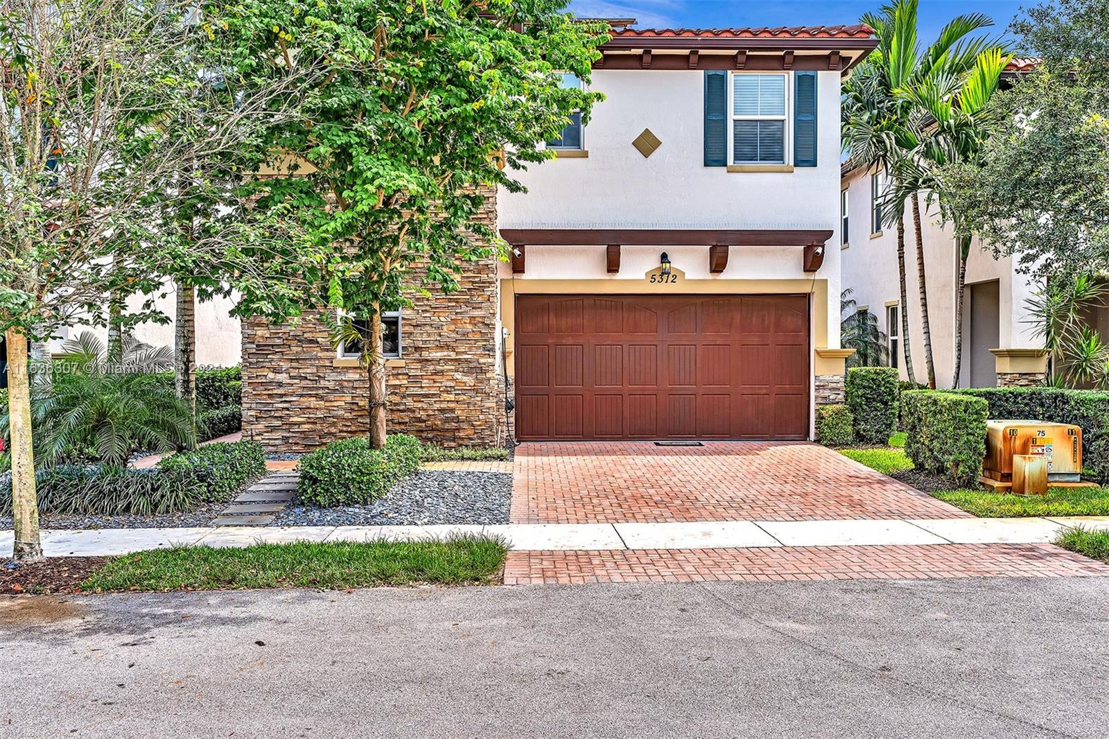 a front view of a house with a yard and a garage