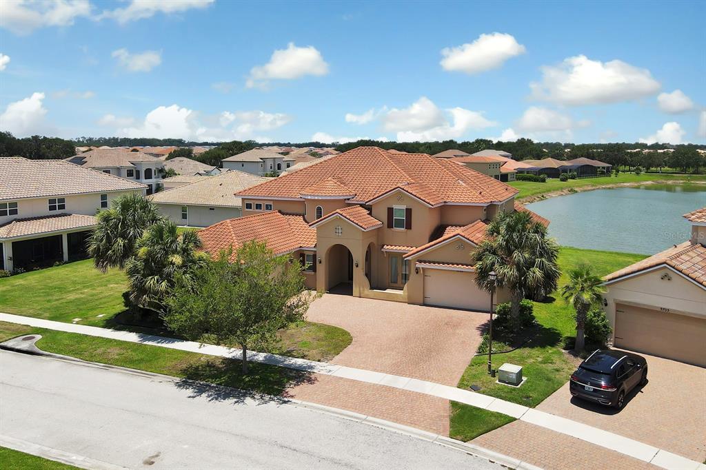 an aerial view of a house with a garden and lake view