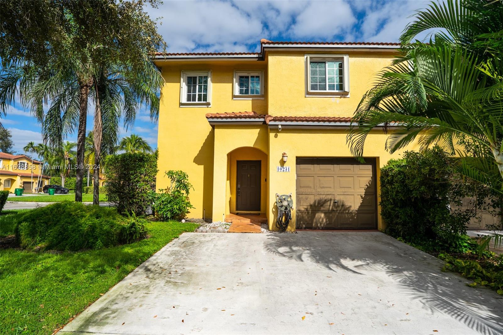 a front view of a house with a yard and a garage