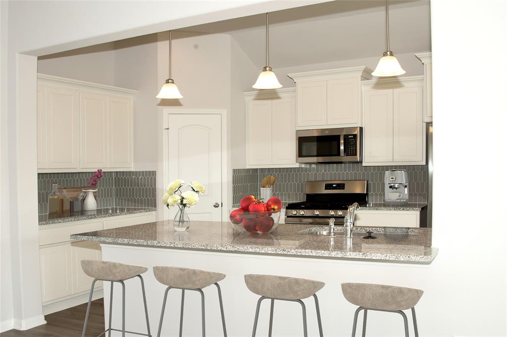 a kitchen with stainless steel appliances a kitchen island a stove a sink and a refrigerator