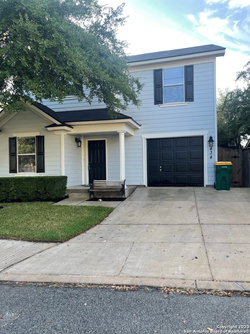 a view of a house with a yard and large parking space