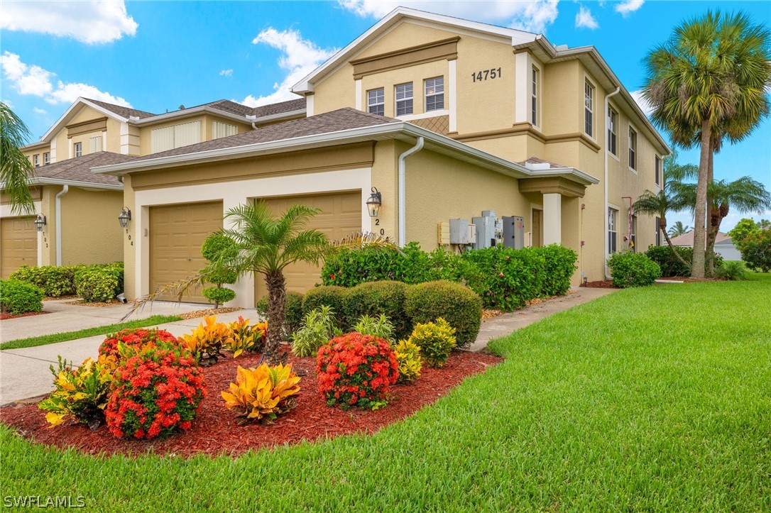 a front view of a house with a big yard and potted plants