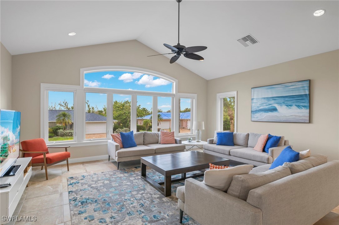 a living room with furniture ceiling fan and a large window