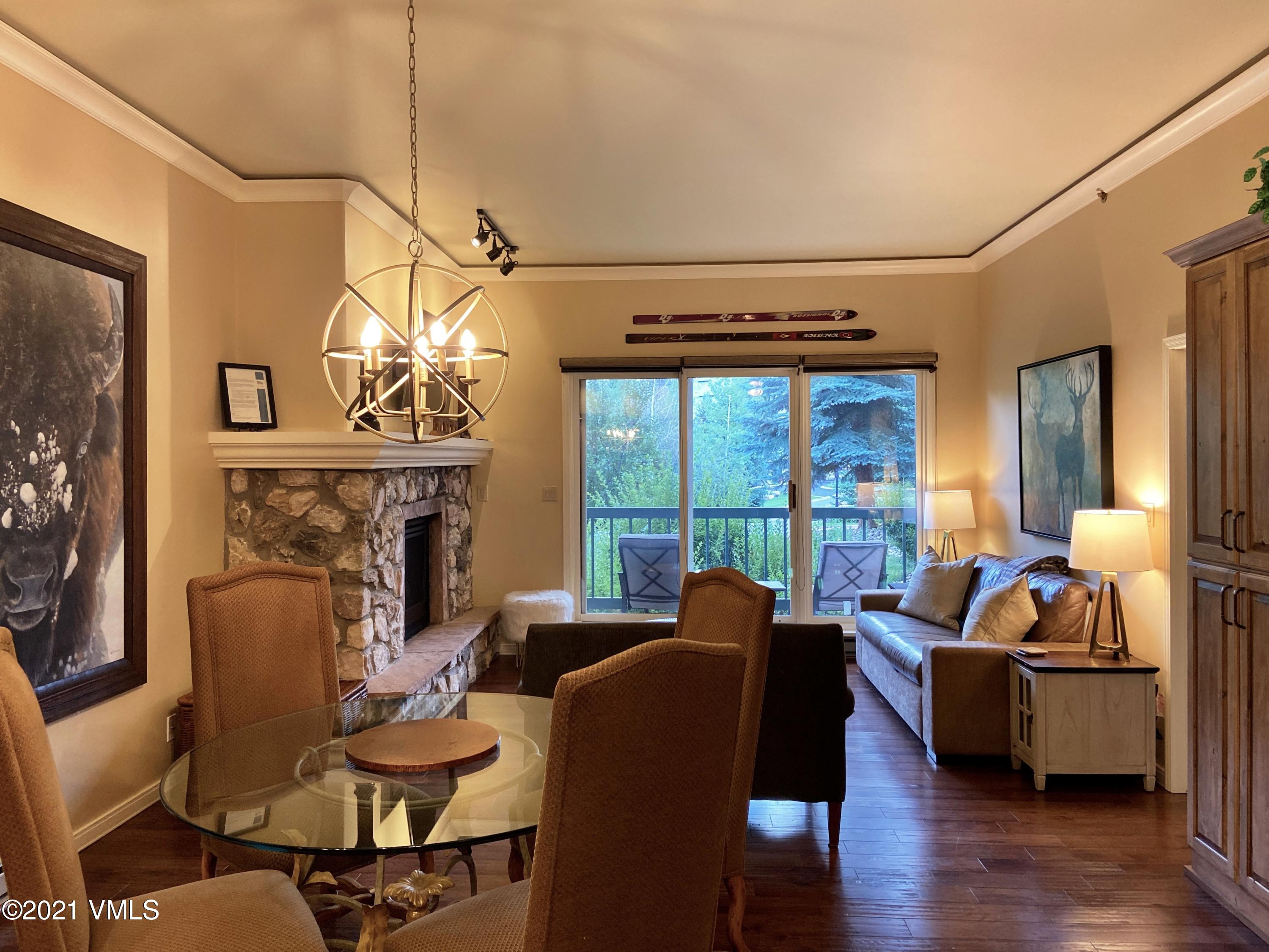 a living room with furniture a fireplace and a floor to ceiling window