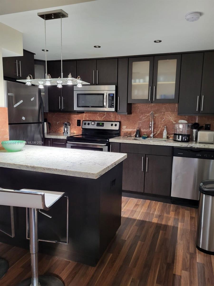 a kitchen with stainless steel appliances granite countertop a sink a stove a microwave a counter top and cabinets