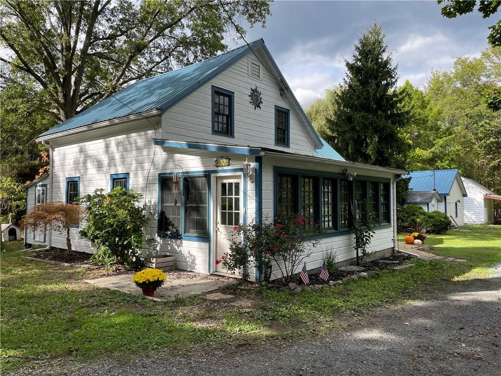 View of front of house featuring a front lawn and a sunroom