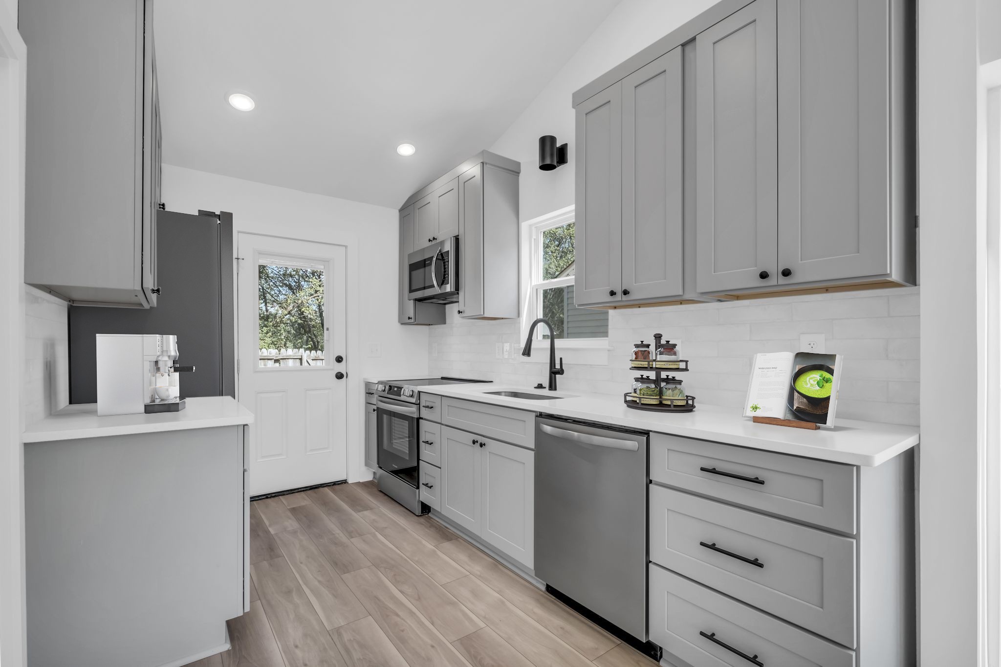 a kitchen with kitchen island granite countertop appliances cabinets and a sink