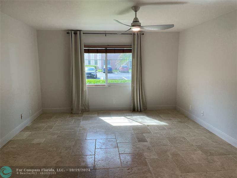 an empty room with windows and fan